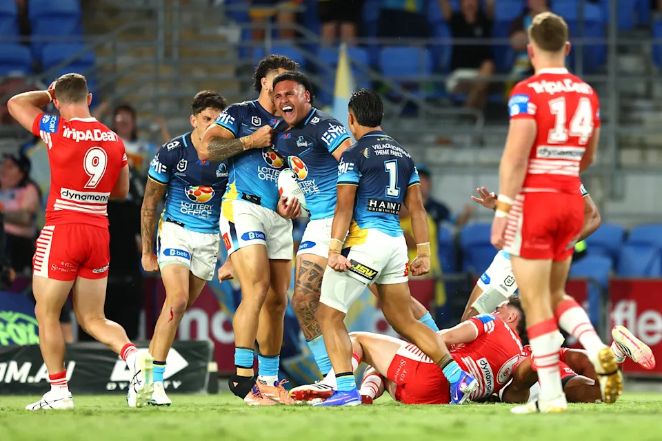 Pictured centre, Gold Coast back-rower Arama Hau after scoring a try against the Dragons.