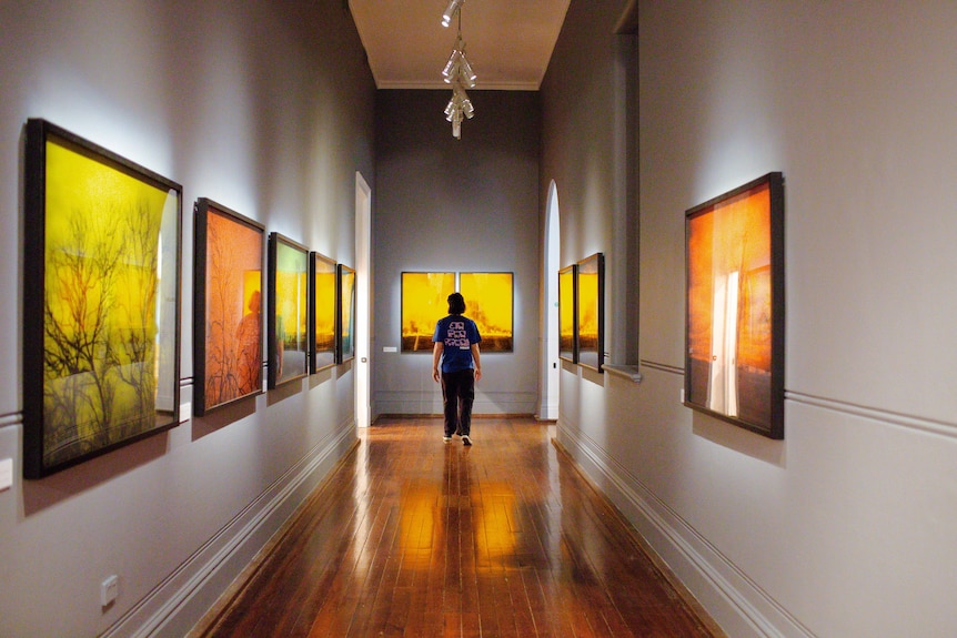 Darkened corridor with series of black and white images overlaid with deep colour