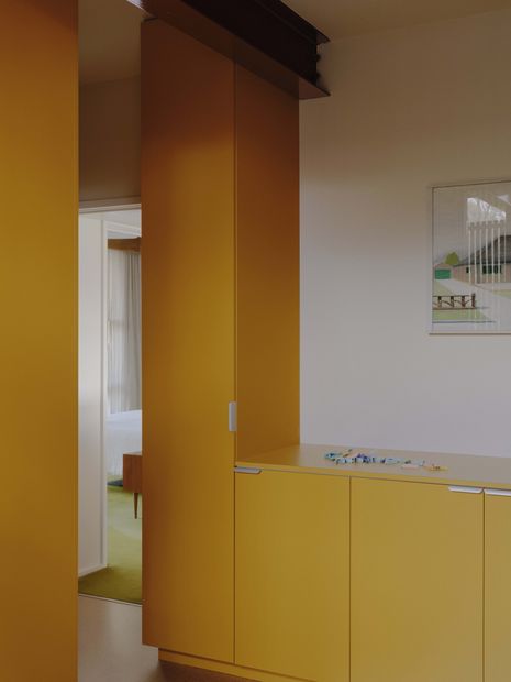 Vivid yellow joinery enlivens the laundry. Artwork: Noel McKenna.
