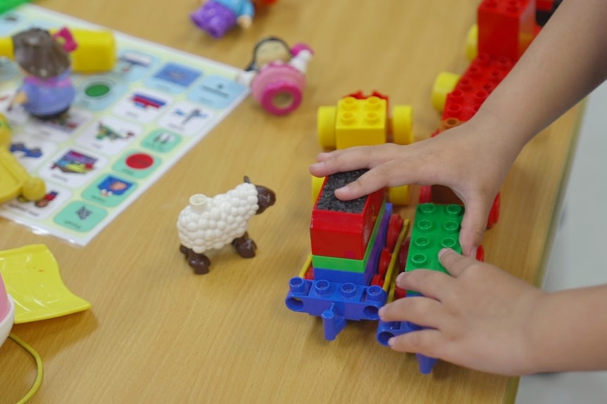 A non-identifiable child playing with toys.