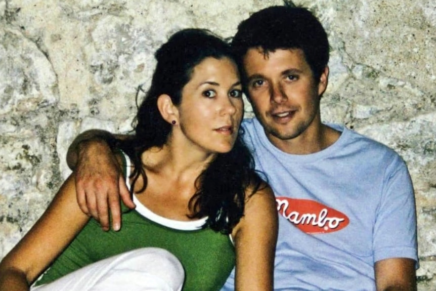 A dark-haired woman and a dark-haired man cuddle up together.