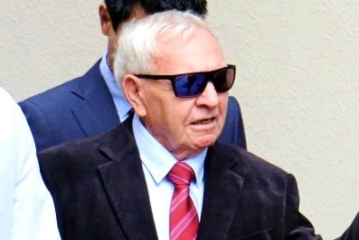 A close up of Barry Cable who wears sunglasses and a suit