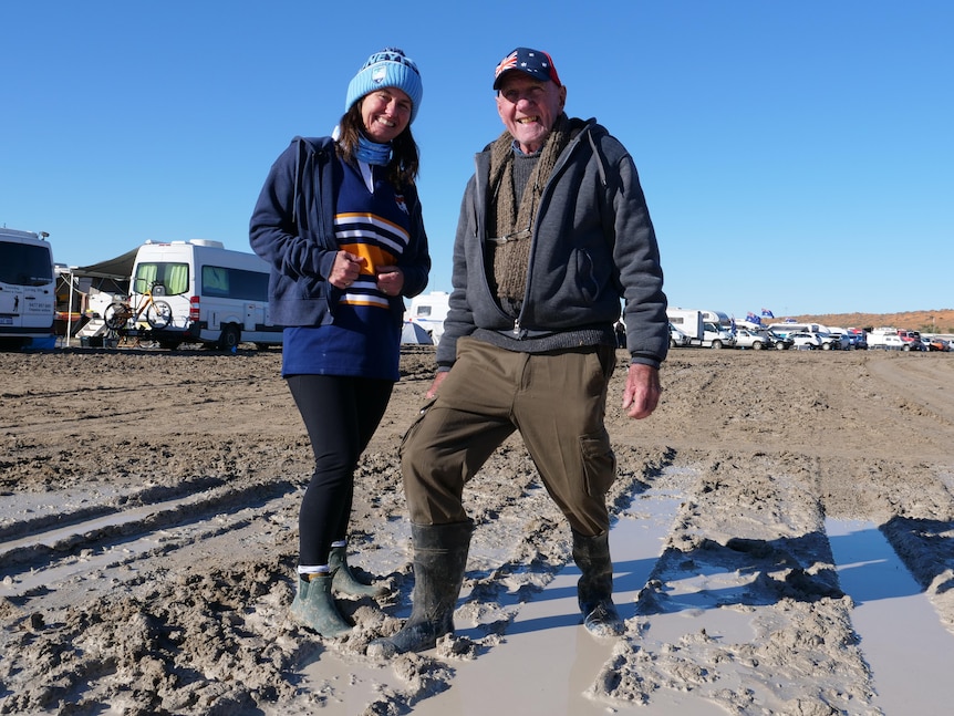 man and woman standing in the mud
