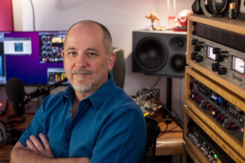 Martin poses for a photo while sitting in a radio studio.