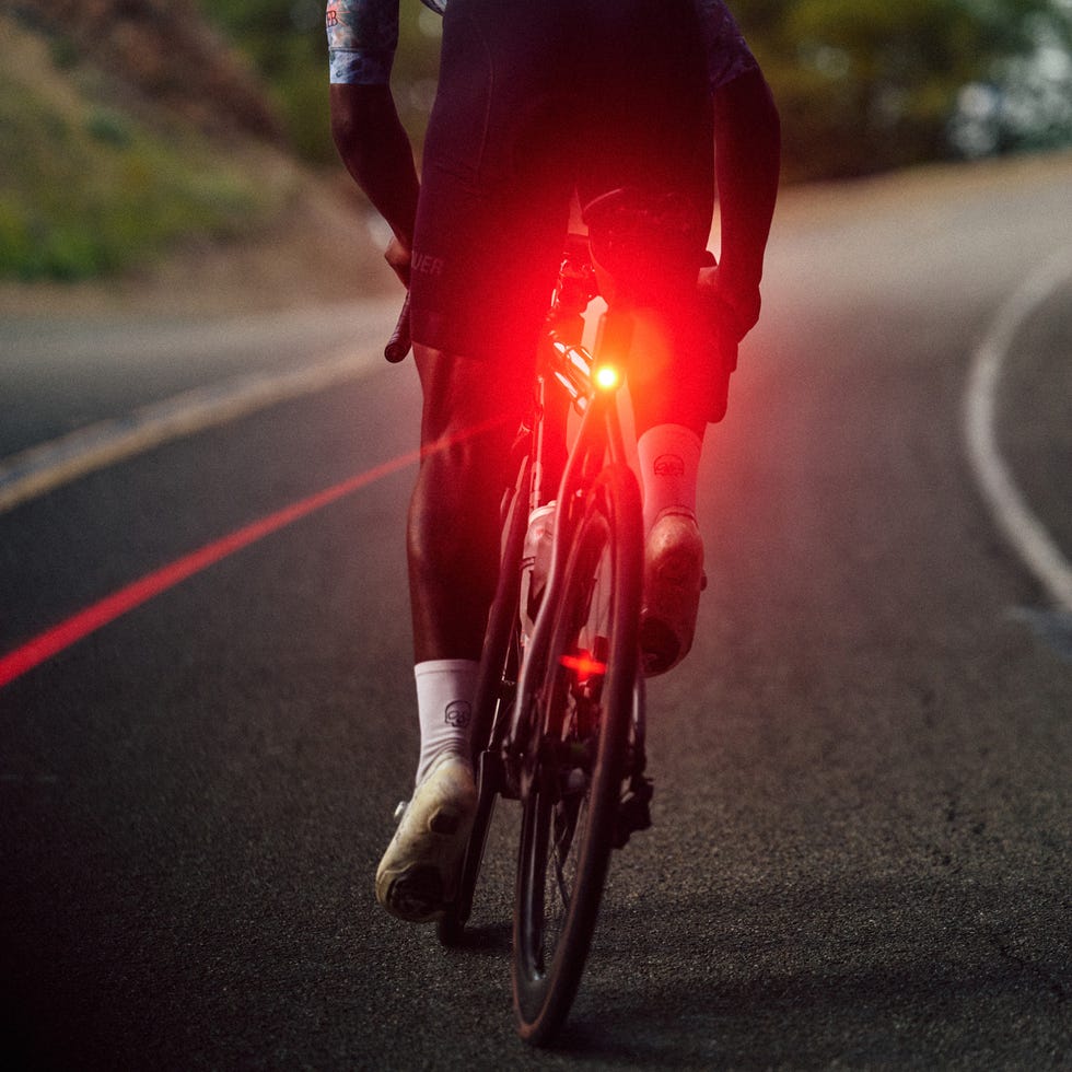 a cyclist riding a bike with a bright red light