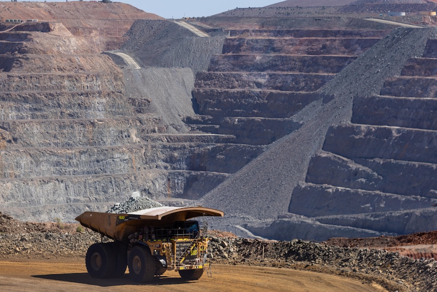 A large mining truck carrying ore inside a mine pit.