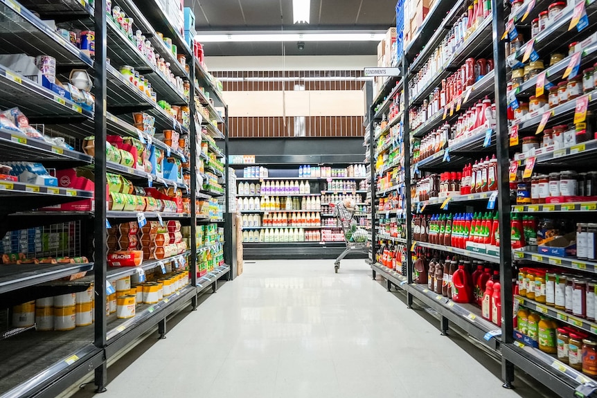 A supermarket aisle stacked with items. 
