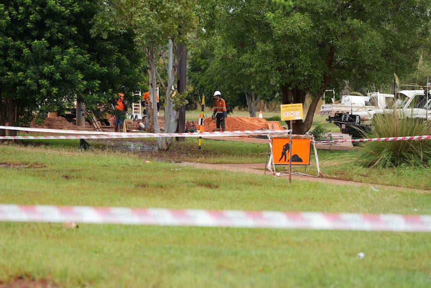 Workers in high vis dig a hole