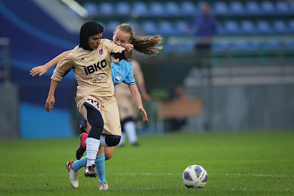 Iranian footballer Mona Hamoudi attempts to get away from a Sydney FC opponent.