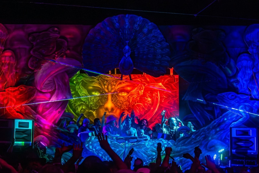 A stage with a DJ and crowd.