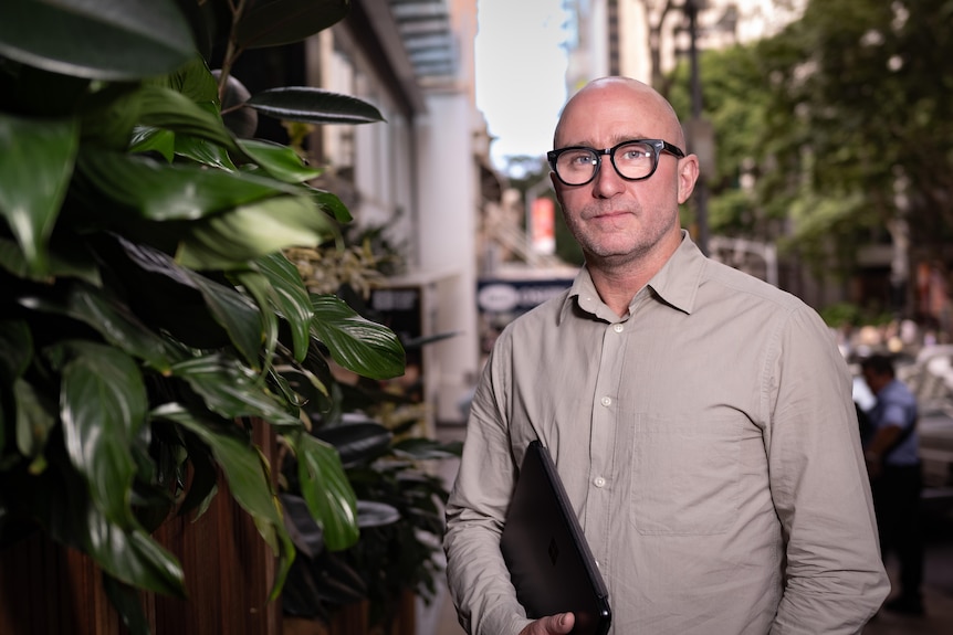 A man with a laptop tucked under his arm