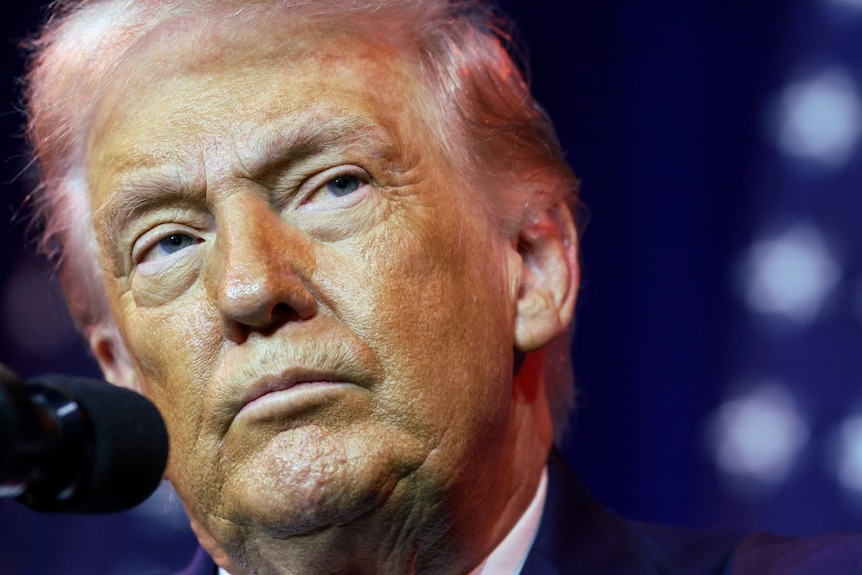 A man in a suit looks on