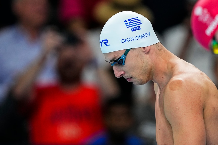 Swimmer Kristian Gkolomeev looks down at the pool before a race