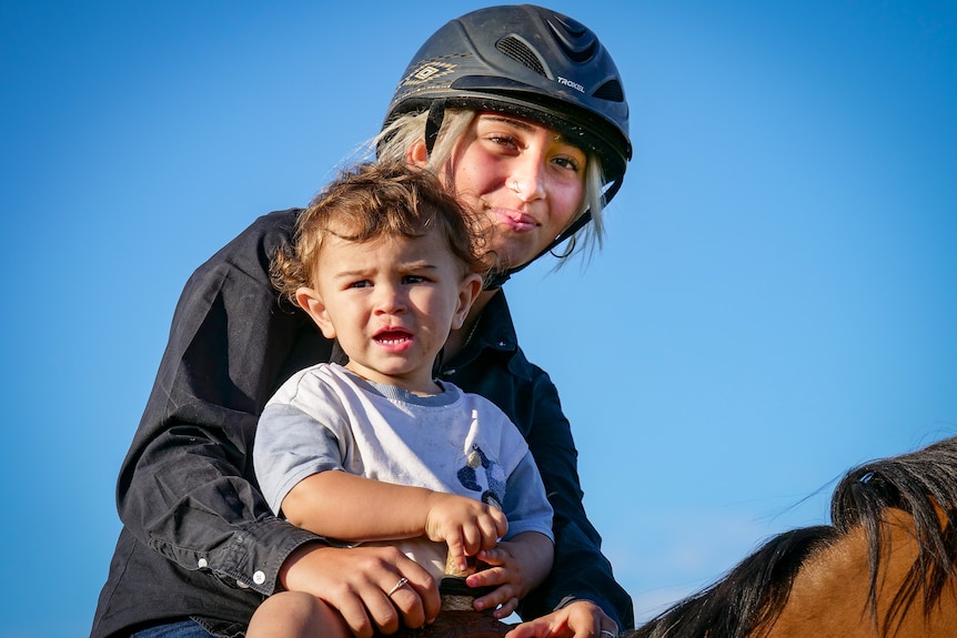 A woman and child on a horse.