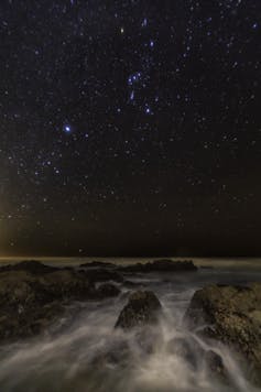 Bright stars visible over a rushing river.