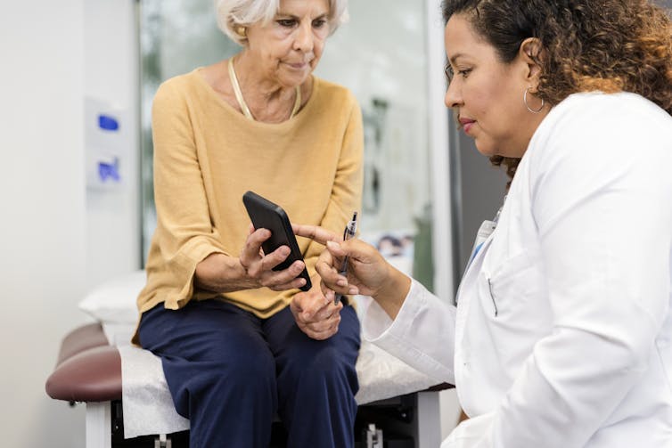 Patient showing doctor their phone in exam room