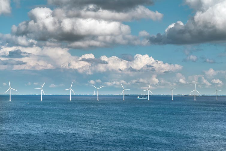 A line of wind turbines in the sea.
