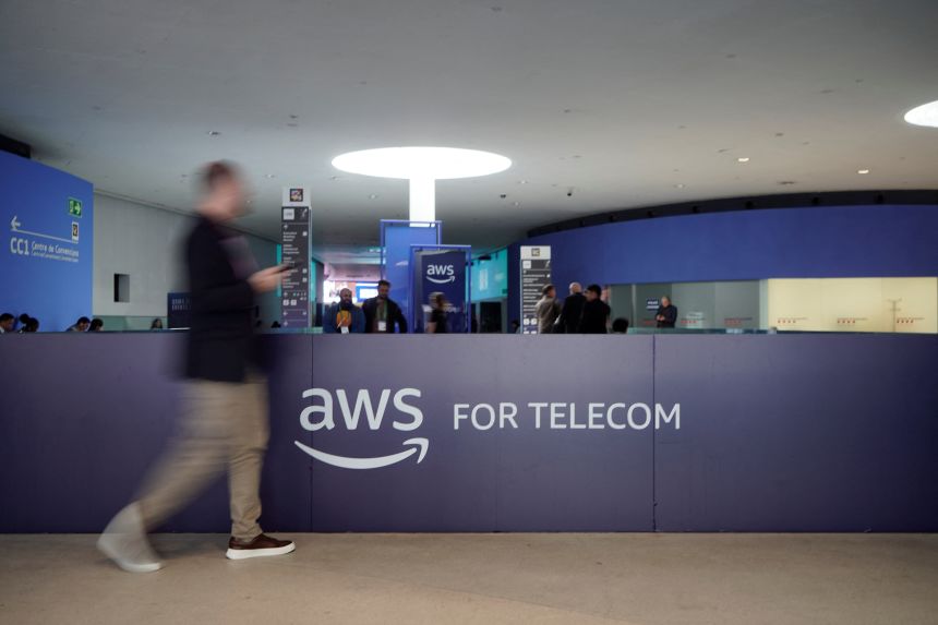 A visitor walks past the logo of Amazon Web Services AWS during the Mobile World Congress (MWC), the world's biggest mobile technology showcase and fair in Barcelona, Spain, on March 2, 2026.