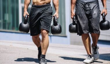Two muscular men performing farmer's carry