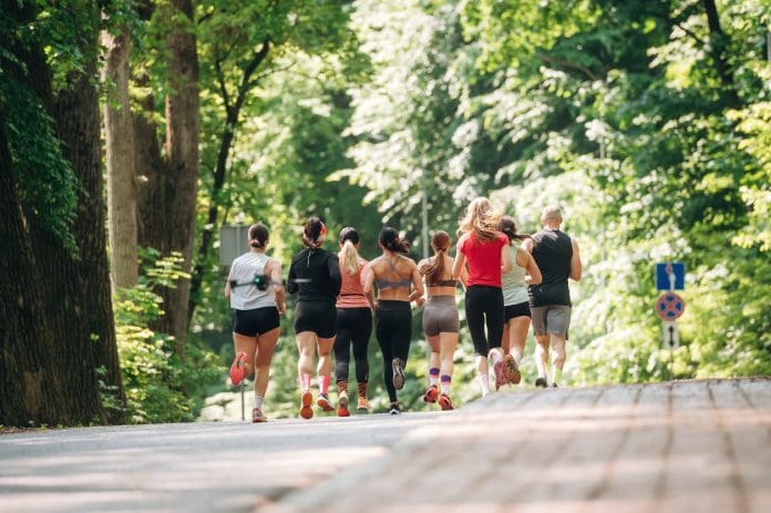 Front view. Group of runners are together outdoors.