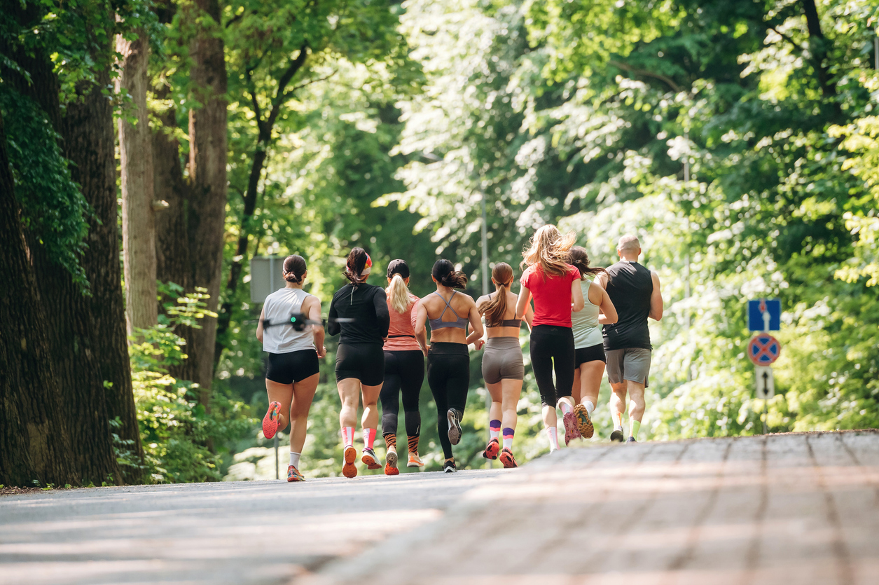 Front view. Group of runners are together outdoors.