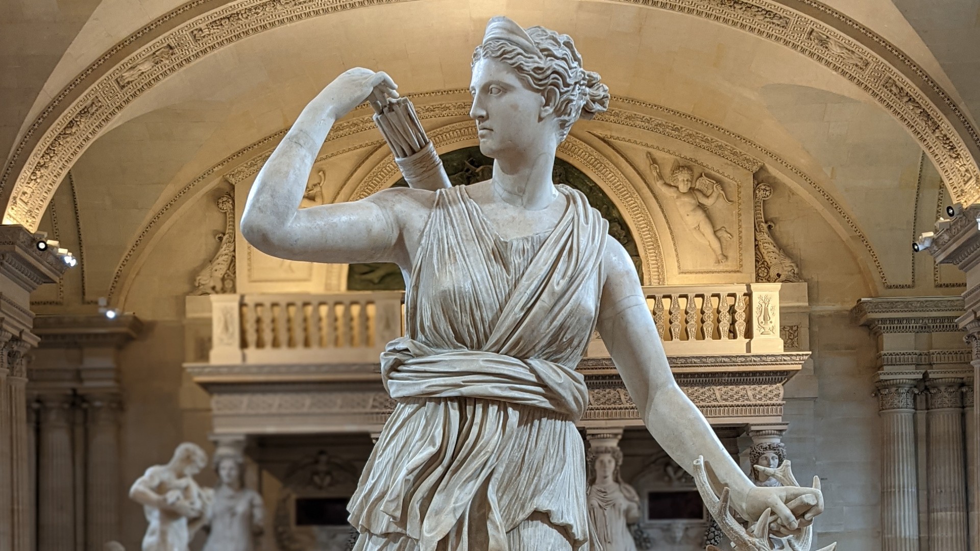 a statue of a female figure holding a quiver of arrows