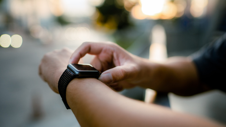 Someone interacting with a smartwatch on their wrist.