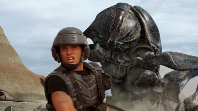 Johnny Rico (Casper Van Dien) fighting a giant alien bug in Starship Troopers