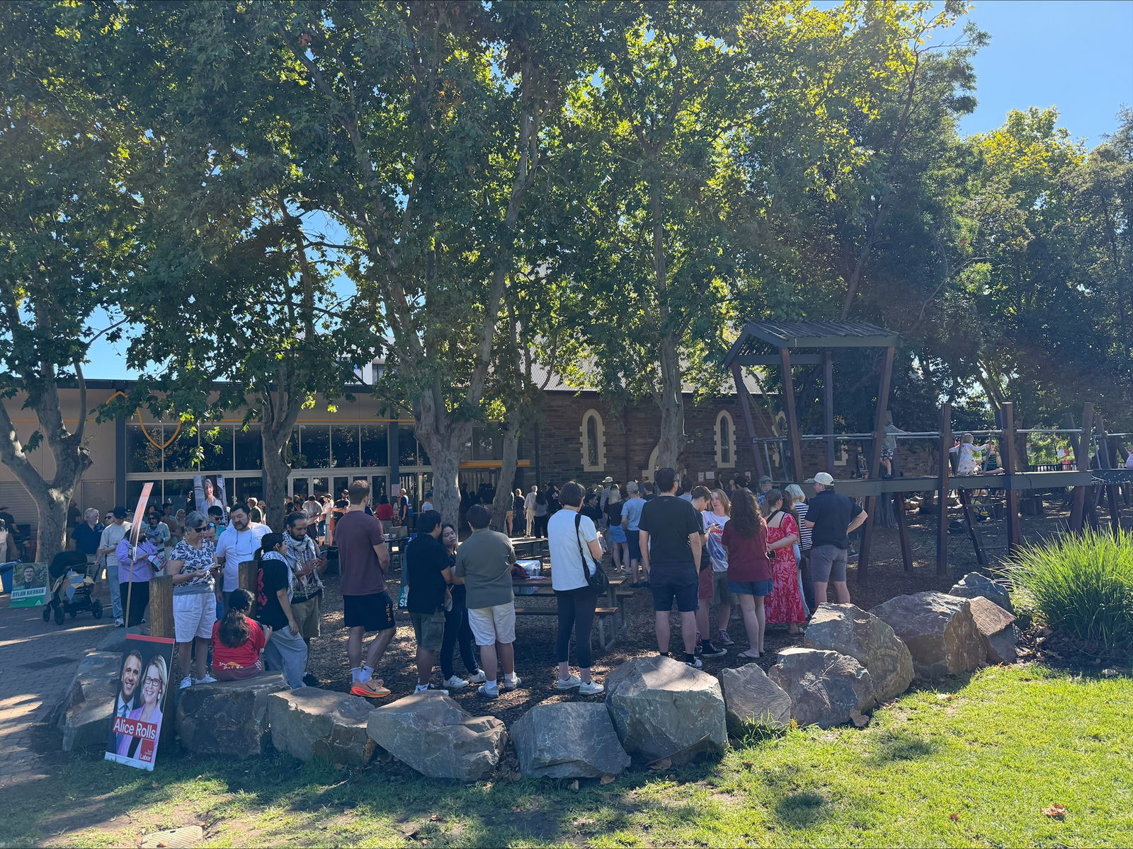 Long queues snake around outside of a primary school