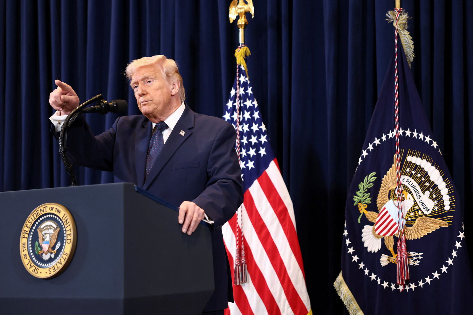 Donald Trump speaks at a podium 