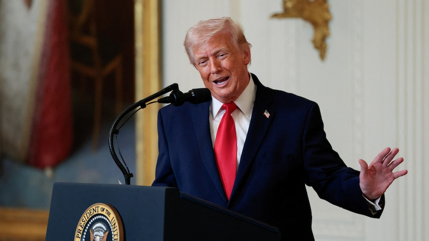 Trump speaks from the white house, gesturing outwards with his left arm