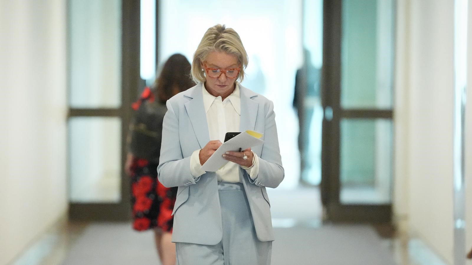 Bridget McKenzie in the hallway on her phone. 