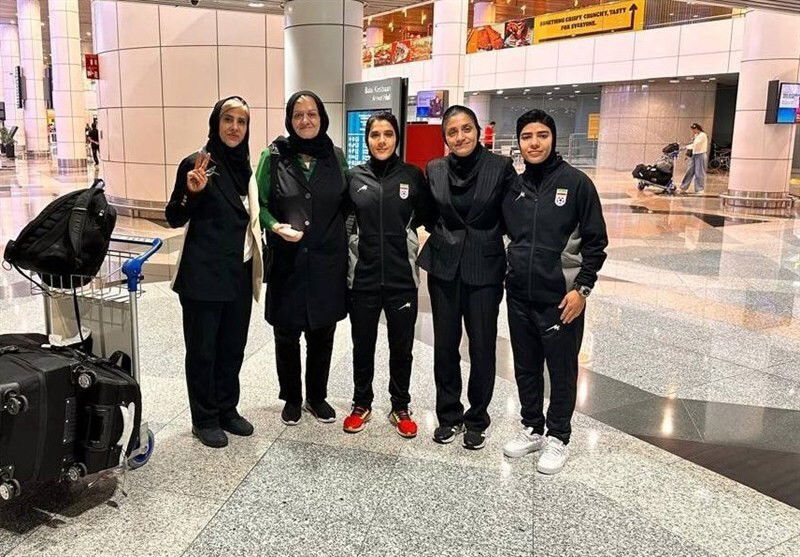Five women at the airport arrivals pose for a photo