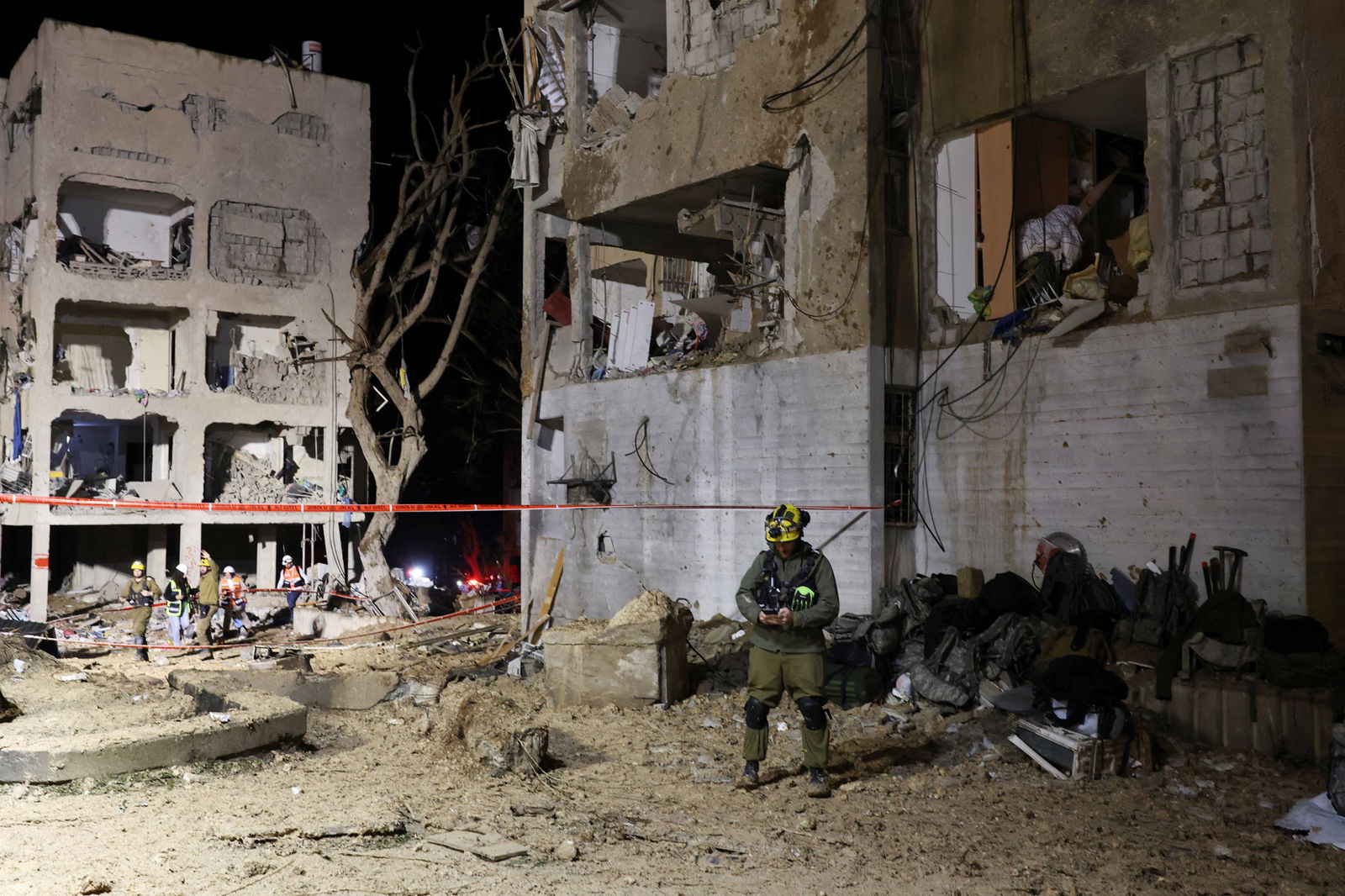 Emergency personnel standing by a damaged building.