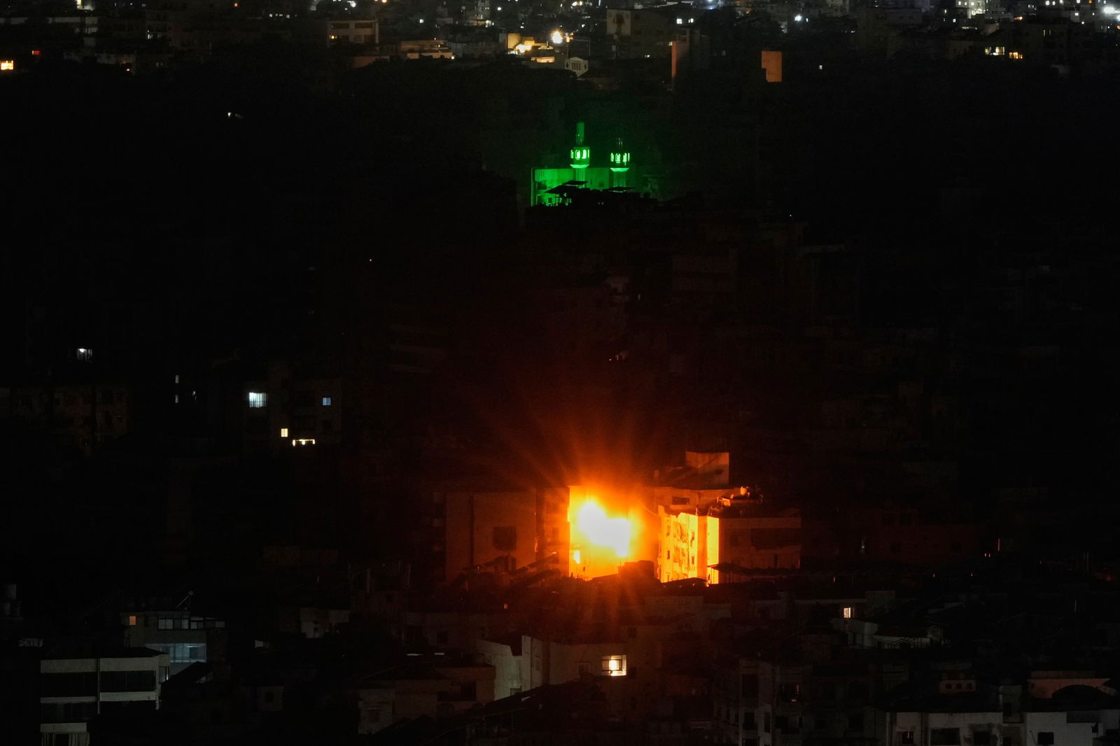 a fireball at night bursts out of an apartment building