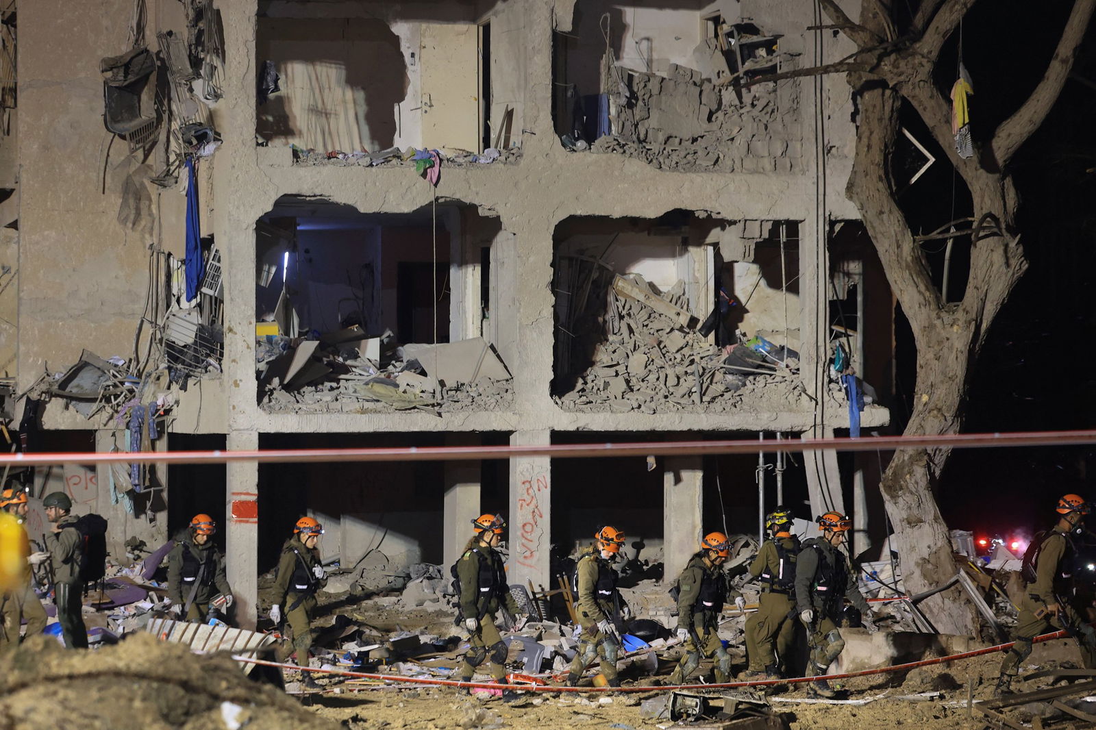 Emergency personnel standing by a damaged building.