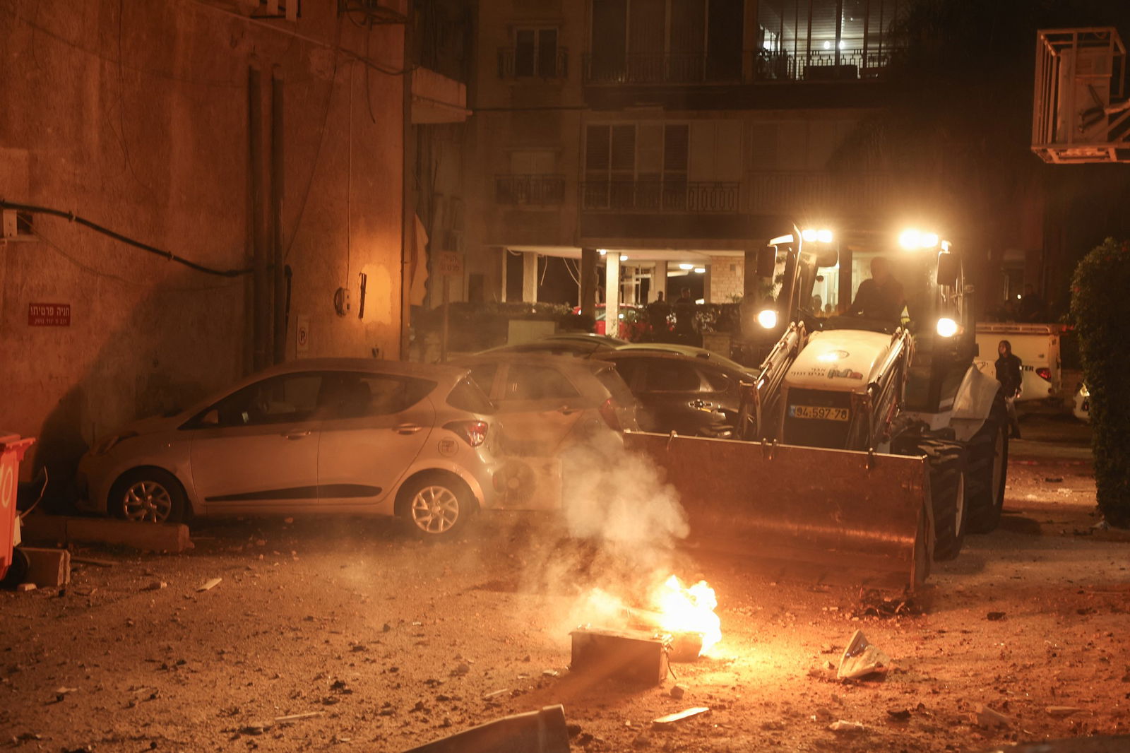 an object on fire scouped up by a digger