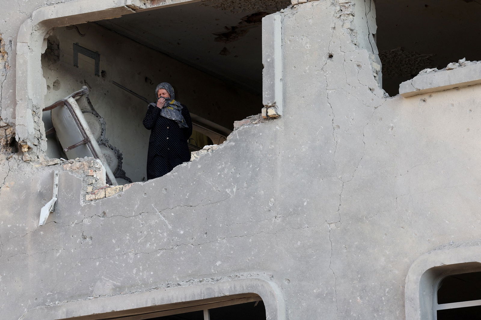 A woman standing inside a destroyed building