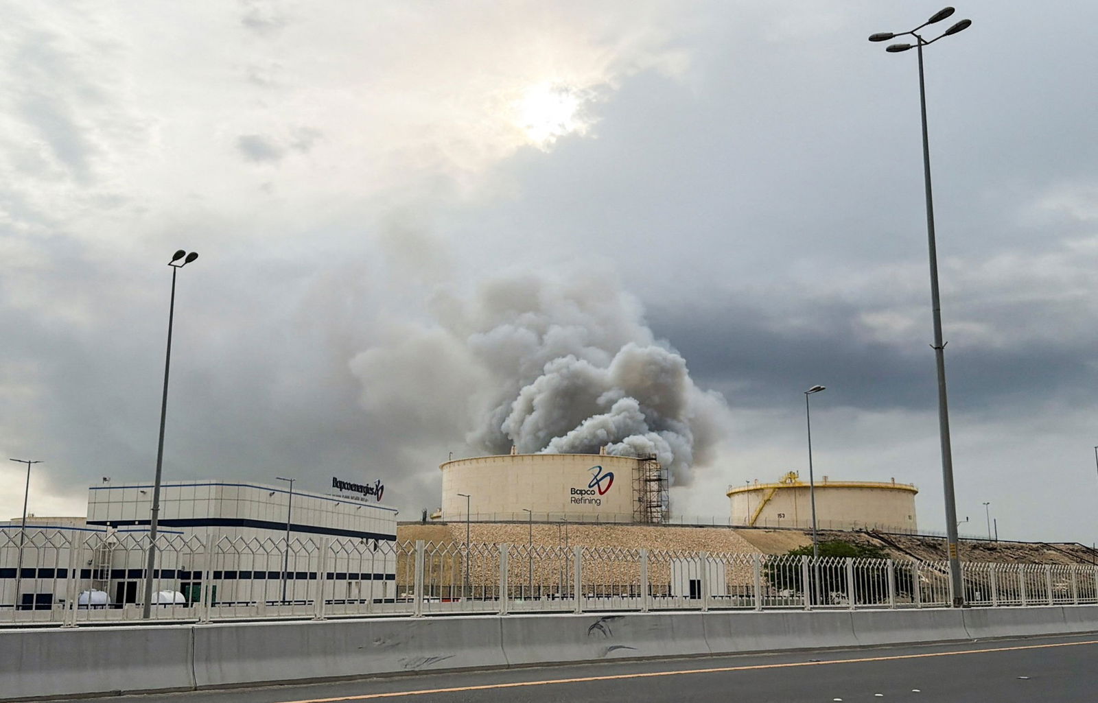 Smoke rises from an oil refinery.