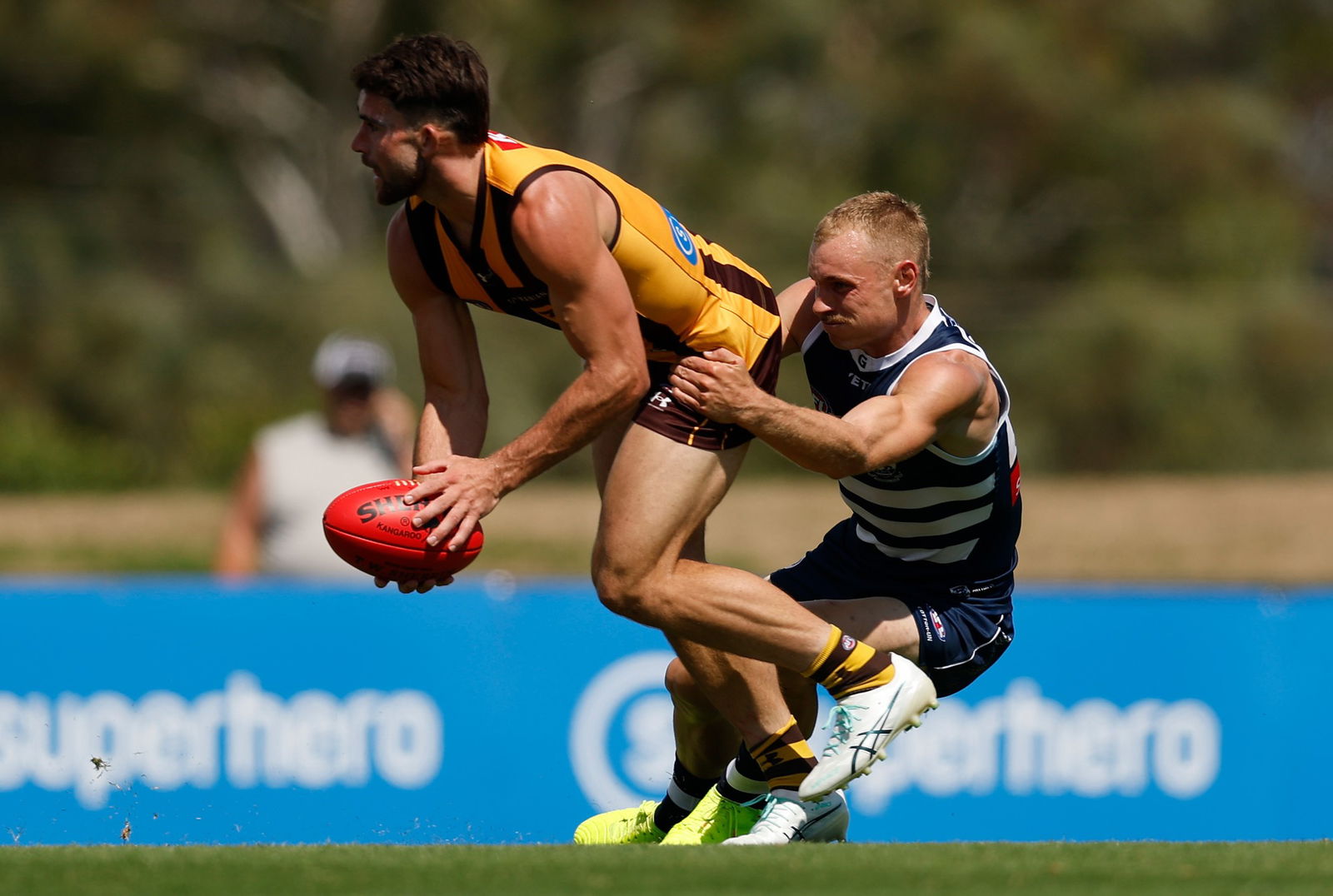 Jai Newcombe of the Hawks is tackled by James Worpel of the Cats during the 2026 AFL match simulation between the Hawthorn Hawks and the Geelong Cats at the Kennedy Community Centre on February 16, 2026 in Melbourne, Australia.