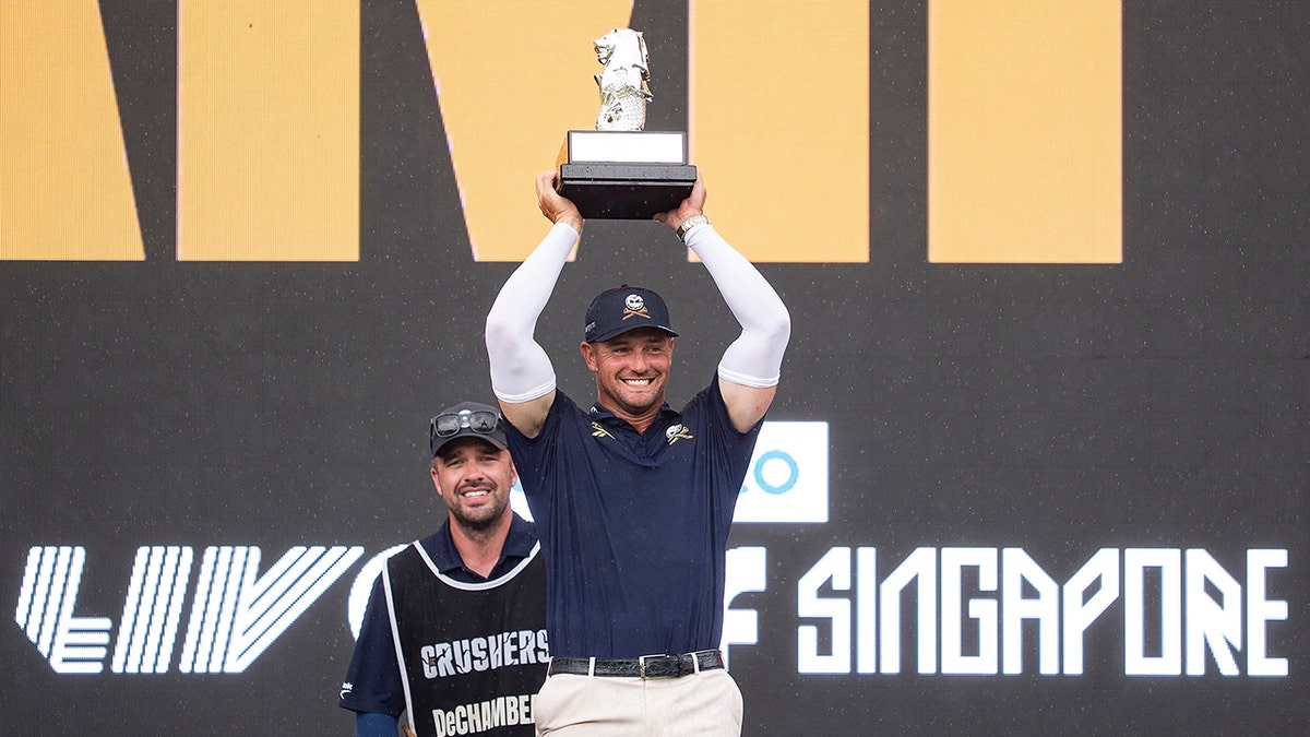 Bryson DeChambeau holds the trophy