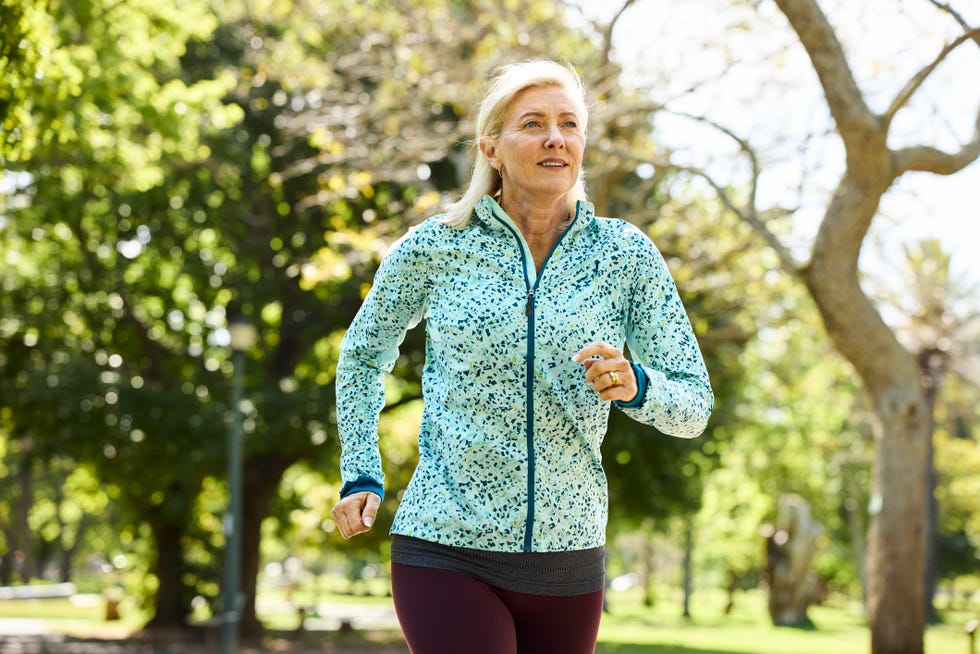 midlife woman jogging in nature.