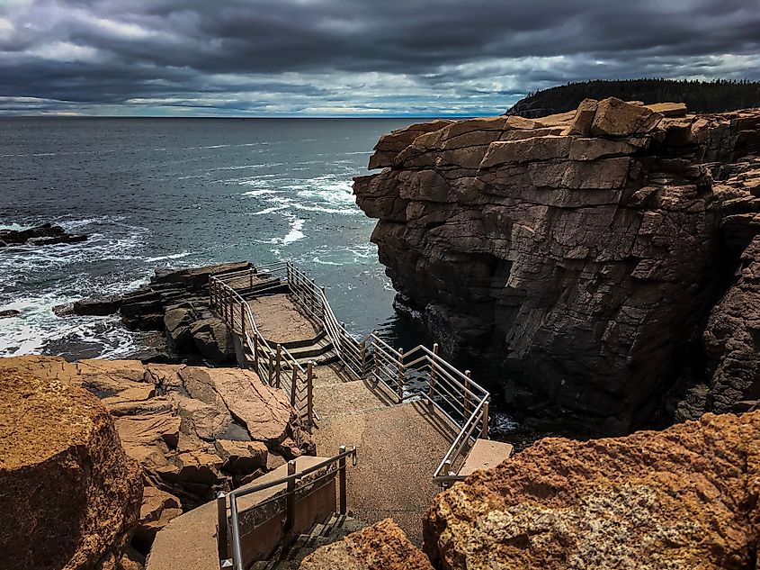 Stairs surrounded by sweeping rocks descend to the ocean at Thunder Hole, Acadia National Park, Maine.