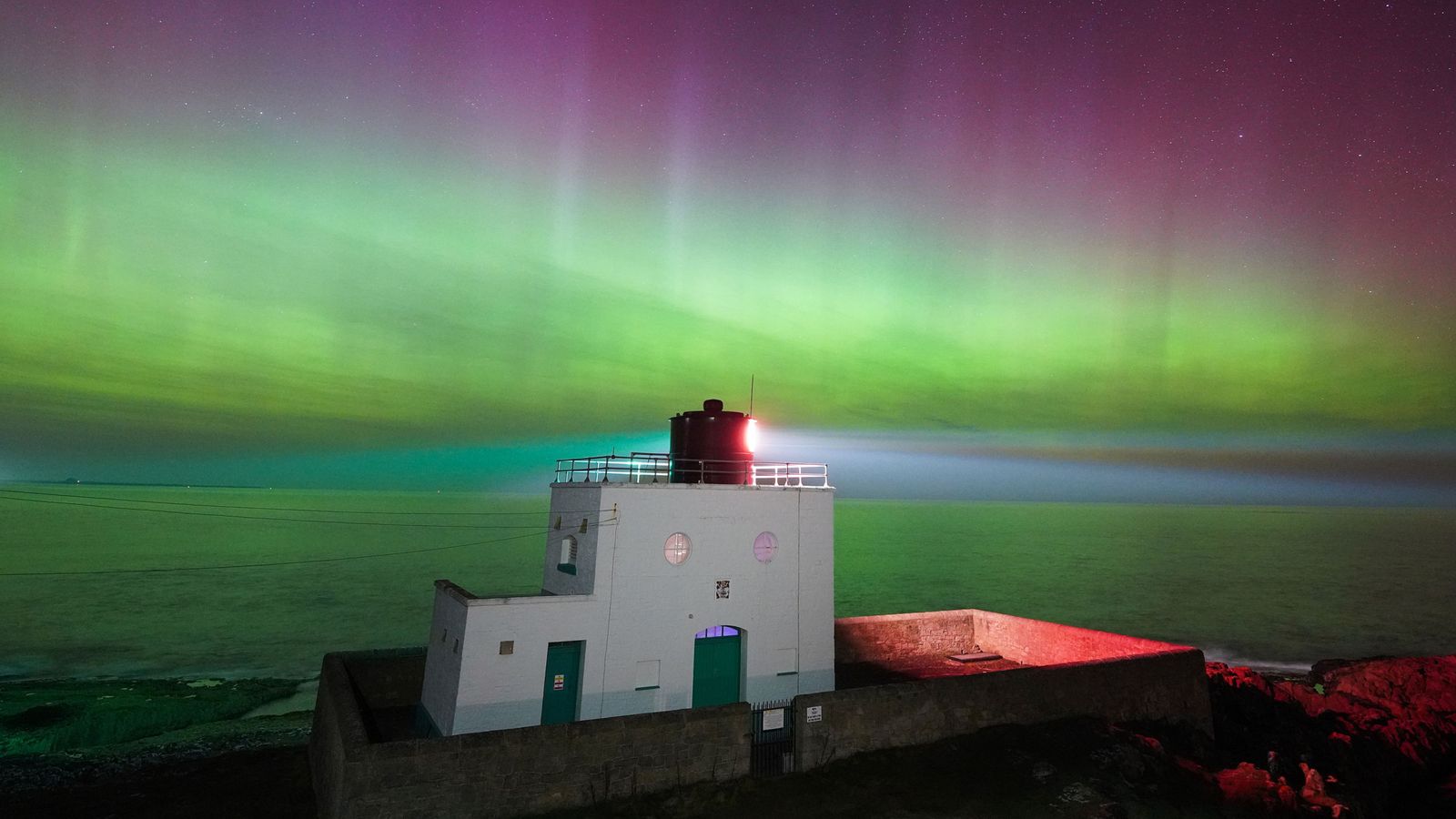 The aurora borealis above Bamburgh Lighthouse in Northumberland. Pic: PA