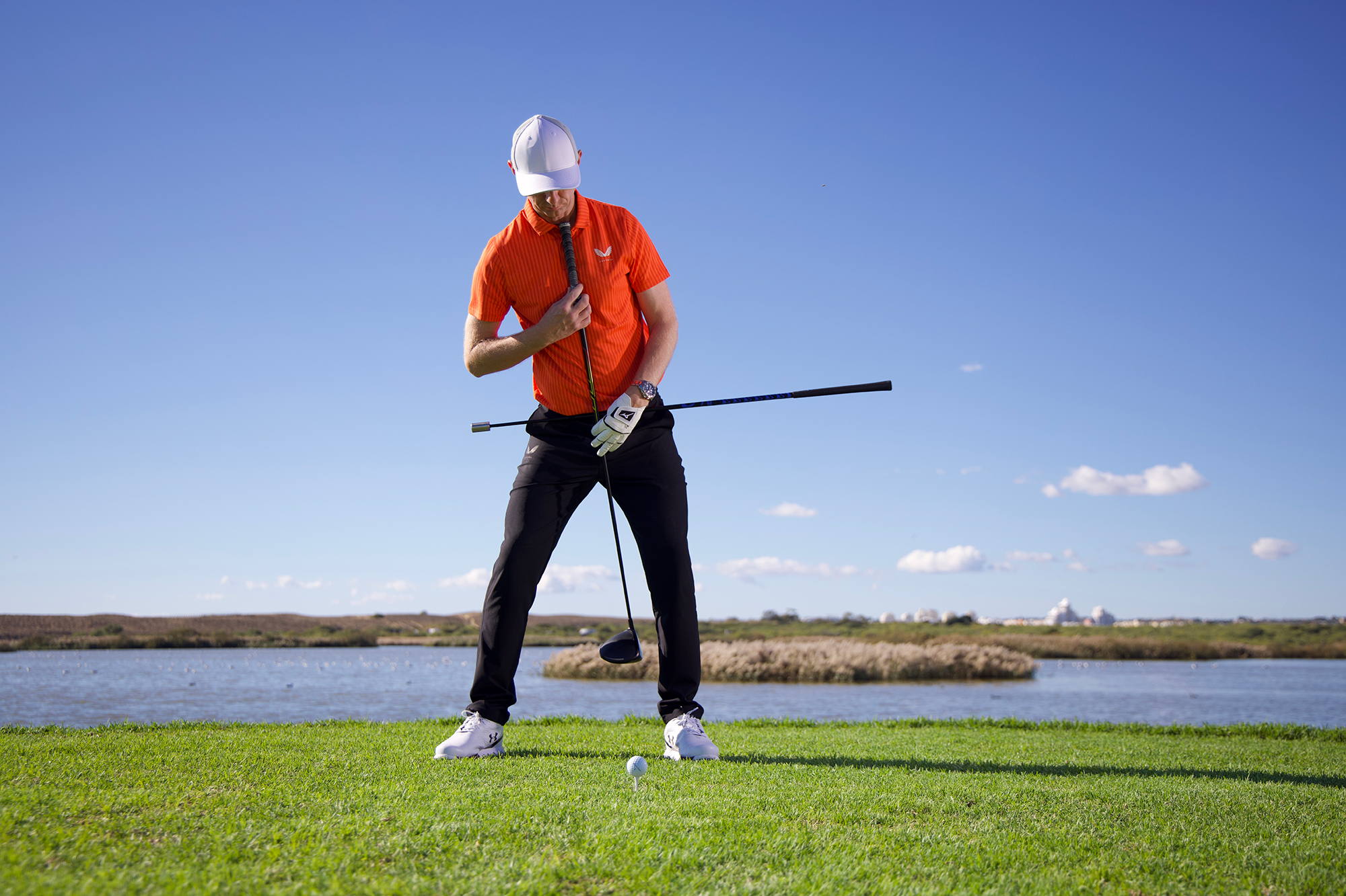 Ged Walters in the correct setup position to hit your driver further, using a driver and alignment stick to reference spine and hip tilt