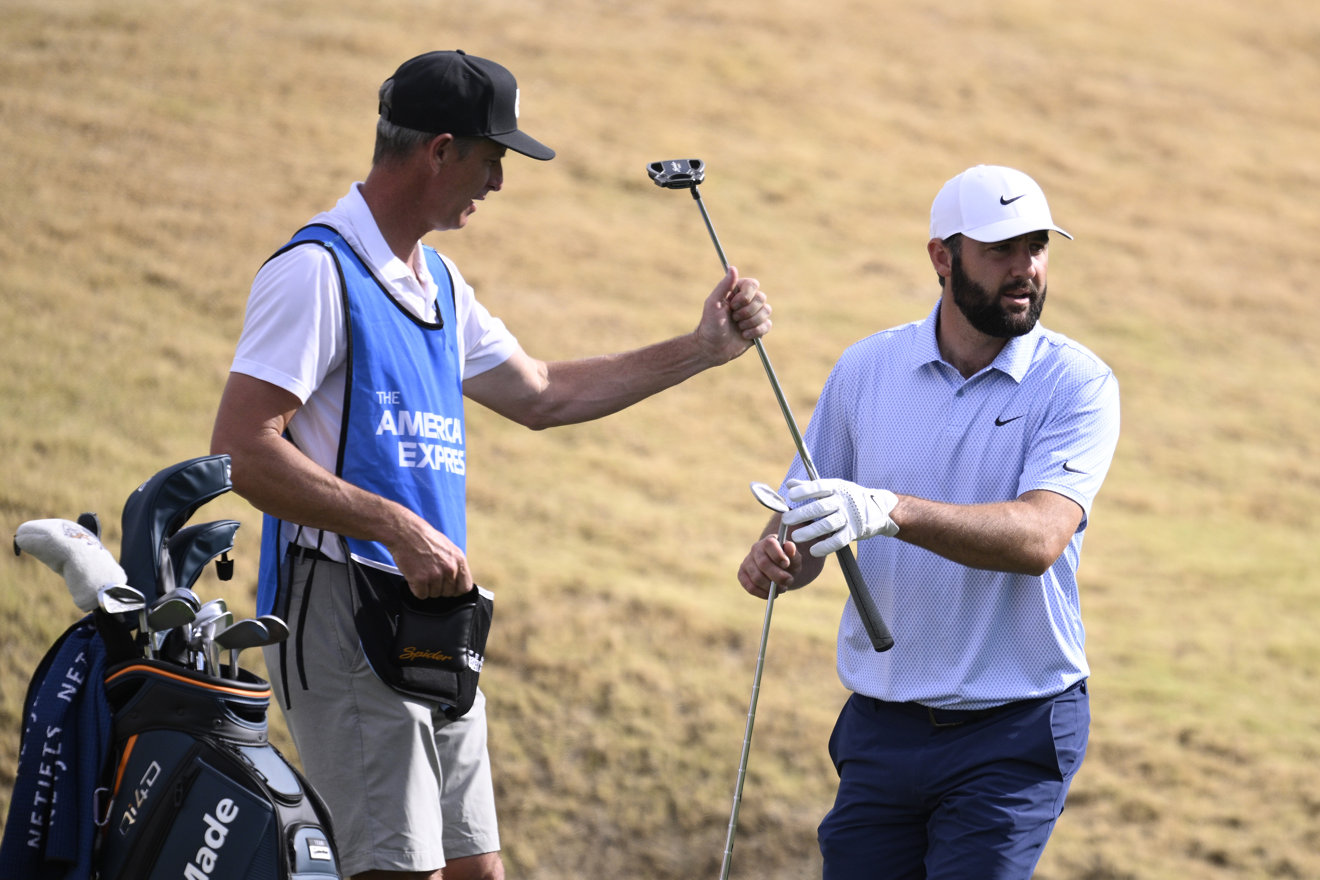 LA QUINTA, CALIFORNIA - JANUARY 25: Scottie Scheffler of the United States takes his putter from his caddie, Ted Scott, on the 11th hole during the final round of The American Express 2026 at Pete Dye Stadium Course on January 25, 2026 in La Quinta, California. (Photo by Orlando Ramirez/Getty Images)
