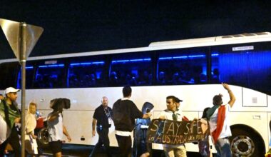 A group of protesters are seen around a bus transporting football players after a match.