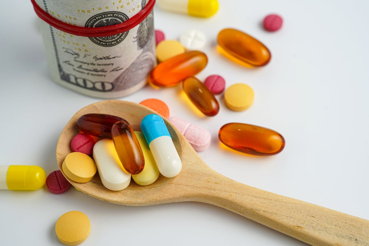 A pile of colorful pills sits in a wooden spoon.