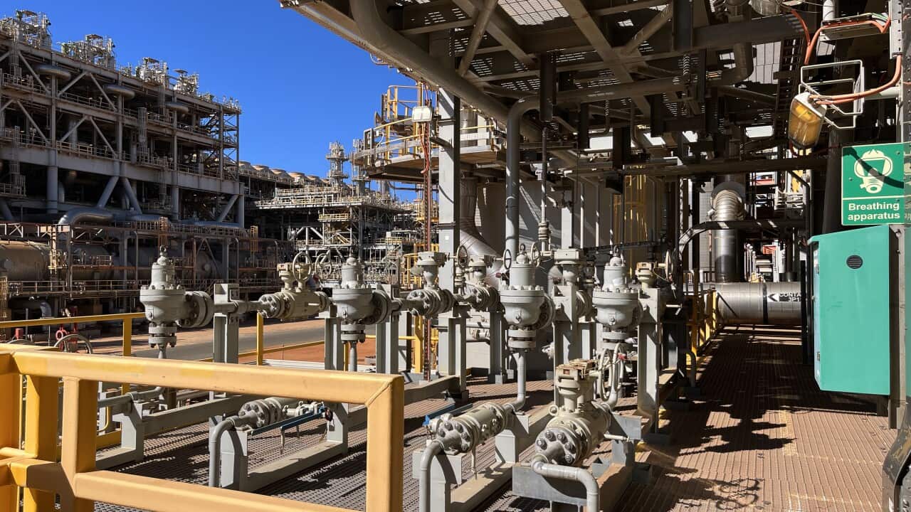 A photo of the Barrow Island natural gas plant in Western Australia. It is a maze of silver pipework against a bright blue sky.