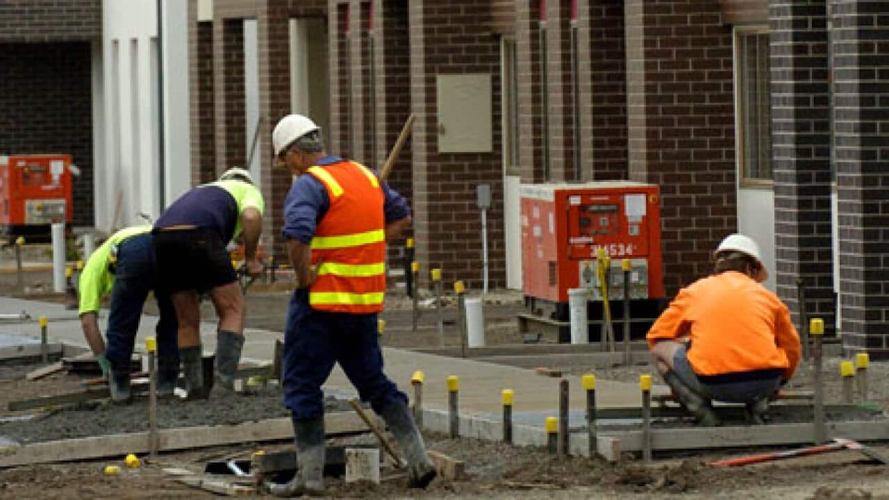 Construction workers in hi-vis working on a job site.